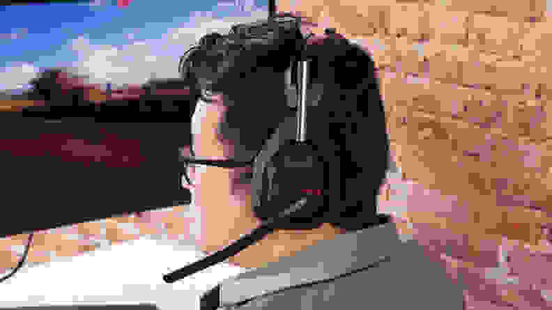 A man wearing a Logitech Astro A50 X, one of the best gaming headsets on the market