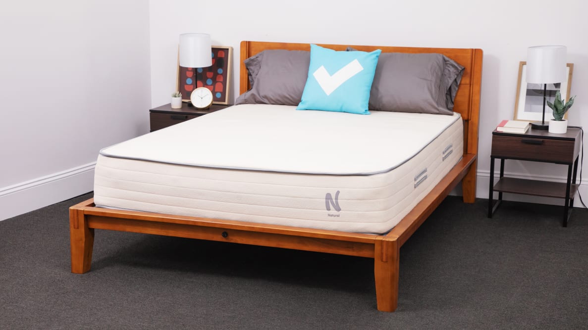 The Nolah Natural mattress inside of a wooden bed frame in bedroom.