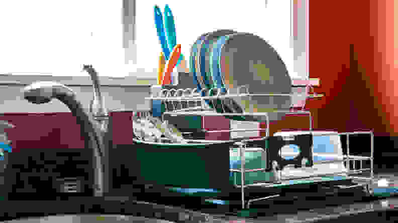 A dish rack full of crockery and cutlery.