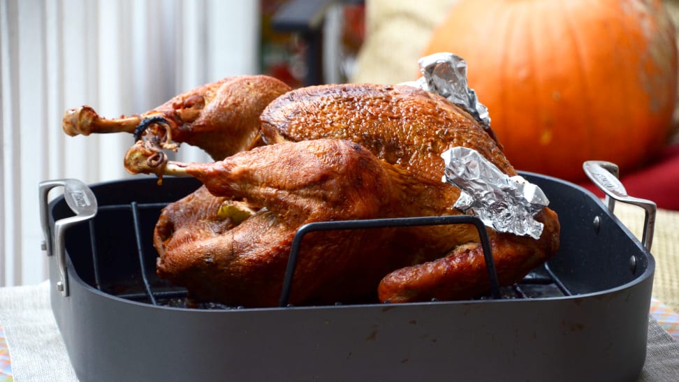 A perfectly browned turkey sits in a roasting pan.