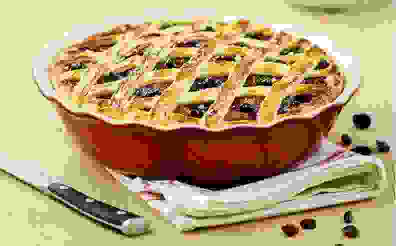 A latticed pie in a red pie dish.