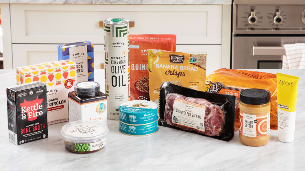 A large collection of Thrive market groceries piled on a counter in a kitchen.