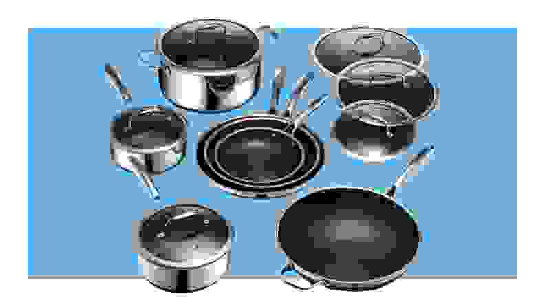 Stainless steel Hexclad Hybrid cookware set with lids in front of blue background.