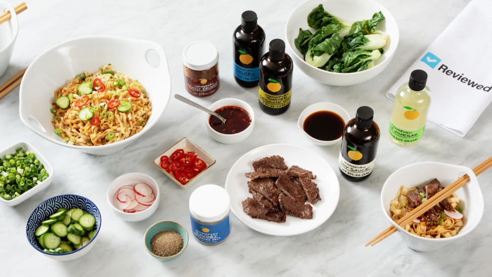 Assorted bowls of ramen, sauces and garnishments from Momofuku on granite countertop