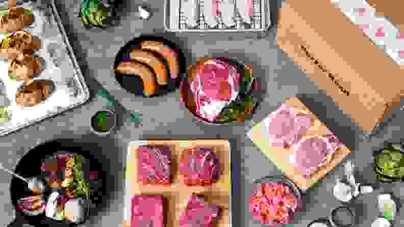 Several raw cuts of meat and a Porter Road box laid out on a countertop