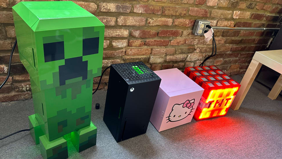 n array of novelty thermoelectric coolers set up to test in our office. They are, from left to right, a cooler in the shape of the Creeper enemy from Minecraft, an XBox, a small cube-shaped cooler with Hello Kitty's face on the front, and a cooler with the shape and design of a Minecraft TNT block.