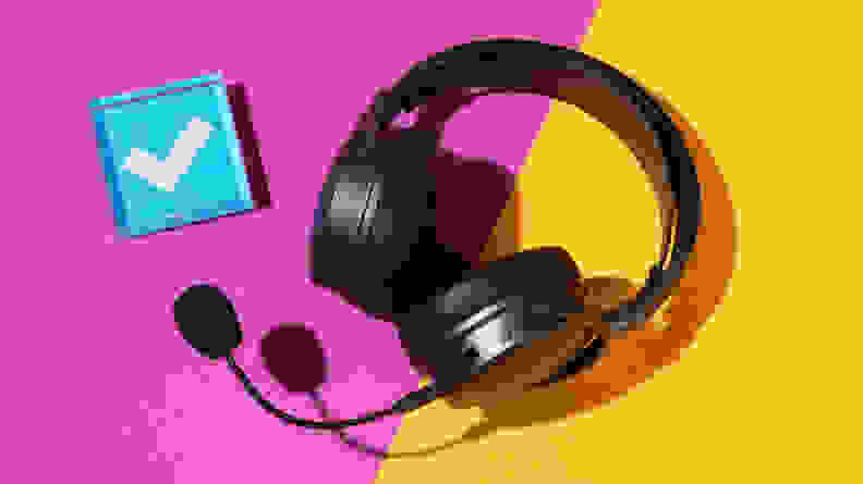 A heavy black gaming headset on a purple and yellow background with a blue checkmark next to it