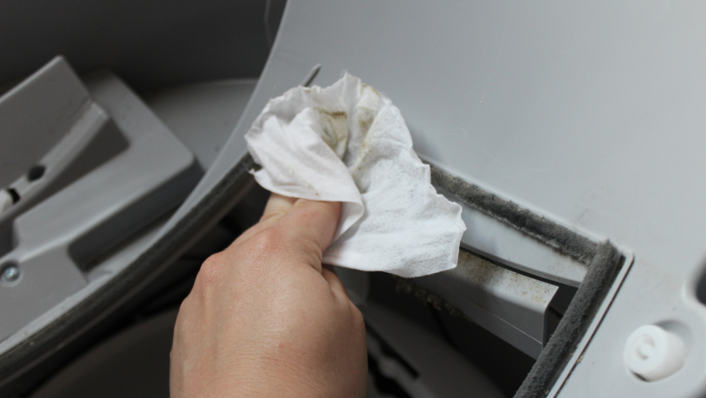 Someone using a disinfecting wipe to clean the base of the Litter-Robot.