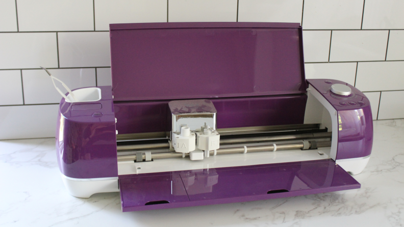 The Cricut Explore Air 2 in a sleek purple opened up to reveal its inner workings.