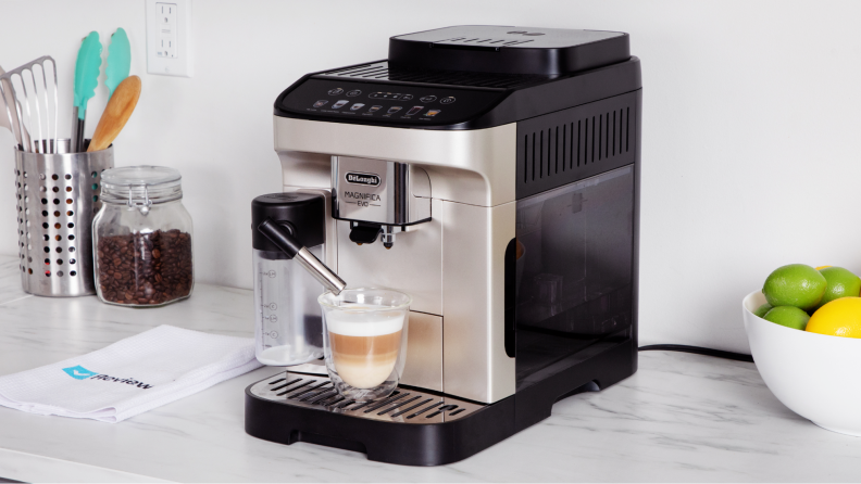 The DeLonghi Magnifica Evo with a cup of freshly brewed coffee in it.