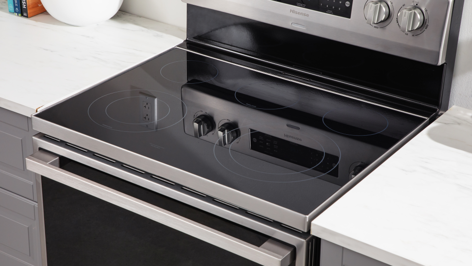 A close-up photo of an electric range highlighting the electric cooktop and the oven control knobs.