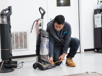 A man in a lab measuring the width of a vacuum.