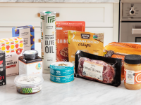 A large collection of Thrive market groceries piled on a counter in a kitchen.