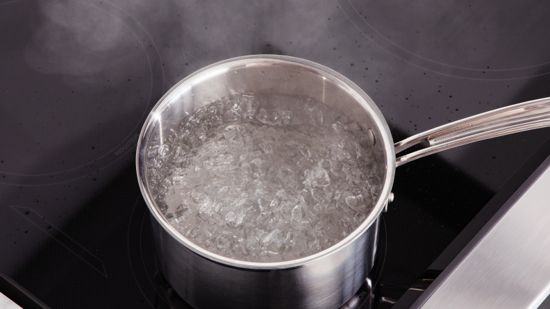 Water boiling in a pot atop the Café CHS900P2MS1 range stove.