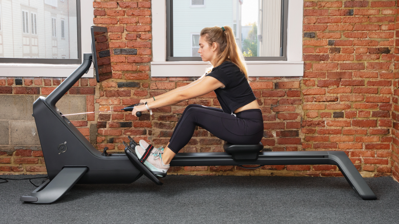 A woman at the catch using the Peloton Row.