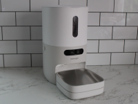 The PawSync Smart Pet Feeder on a marble countertop in front a tiled wall.